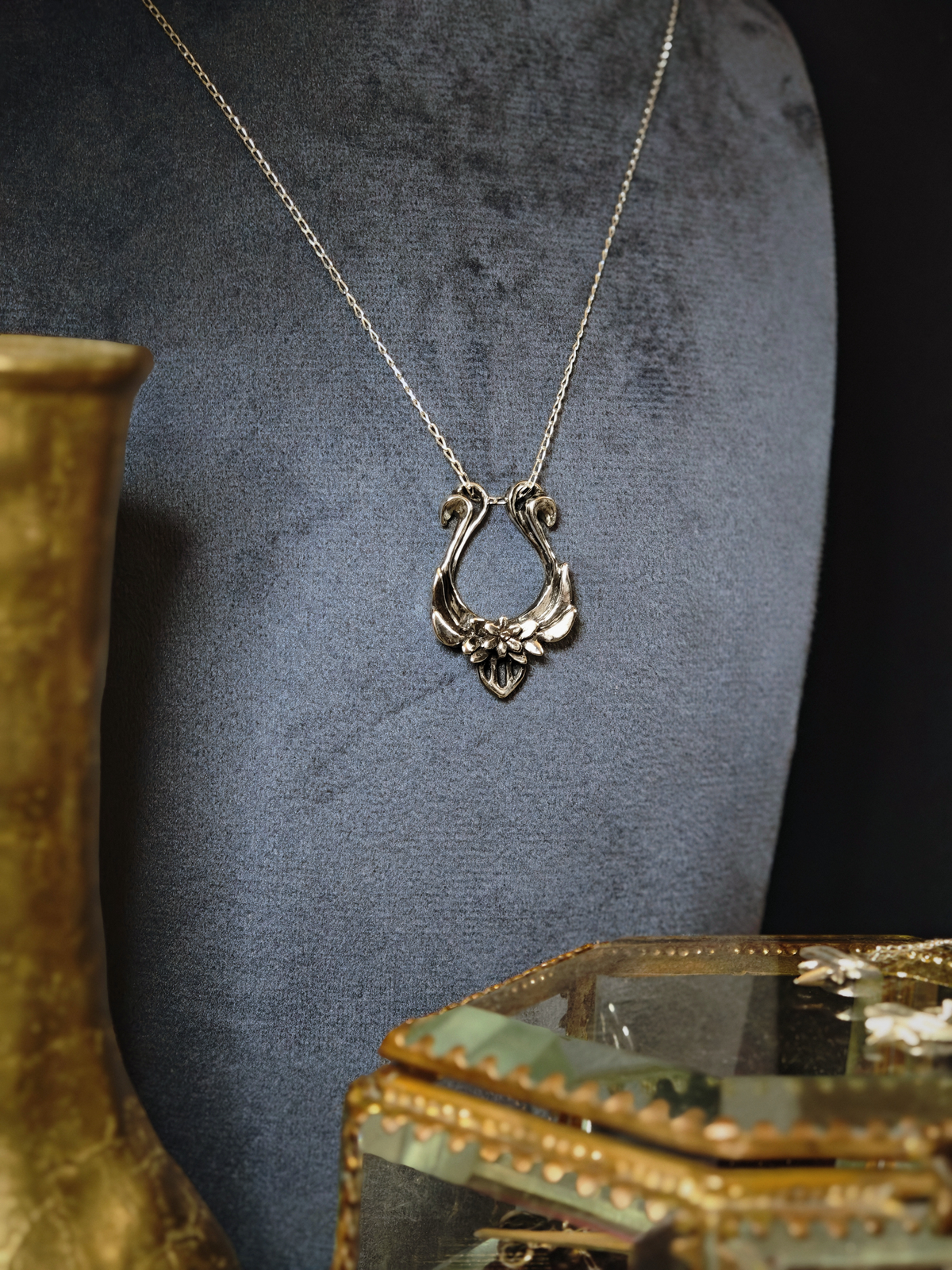 Pendentif lyre d'Orphée en argent 925 présenté sur un buste en velours gris